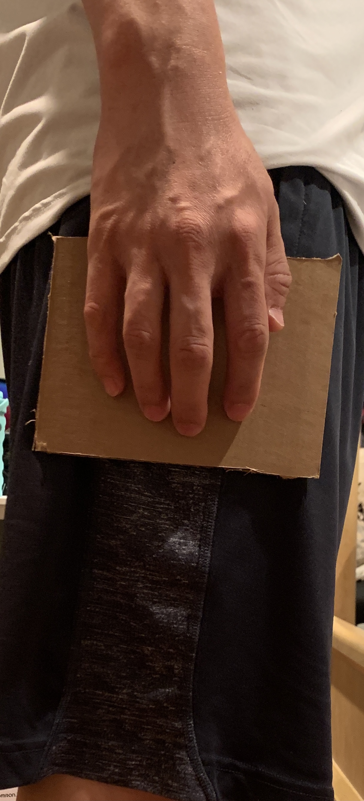 person holding a cardboard prototype at thigh level